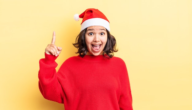 Jeune femme hispanique se sentant comme un génie heureux et excité après avoir réalisé une idée. notion de noël