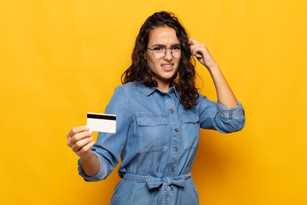 Jeune femme hispanique se sentant confuse et perplexe, montrant que vous êtes fou, fou ou hors de votre esprit