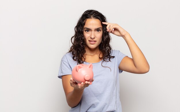 Jeune femme hispanique se sentant confuse et perplexe, montrant que vous êtes fou, fou ou hors de votre esprit