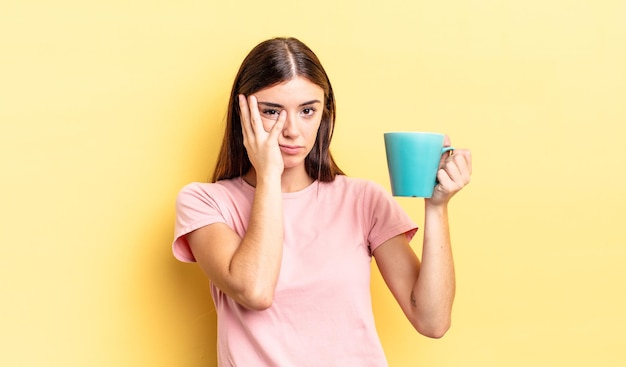 Jeune femme hispanique se sentant ennuyée, frustrée et endormie après une période fastidieuse. concept de tasse à café