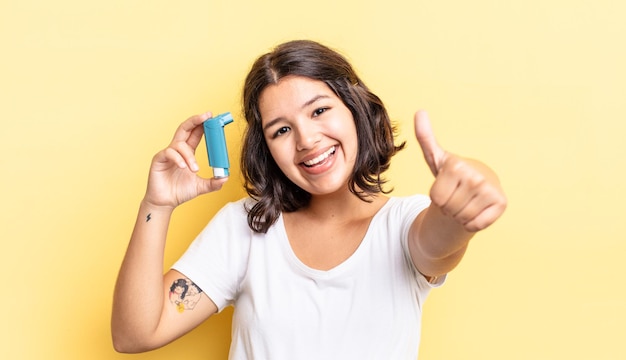 Jeune femme hispanique se sentant fière, souriant positivement avec les pouces vers le haut. notion d'asthme