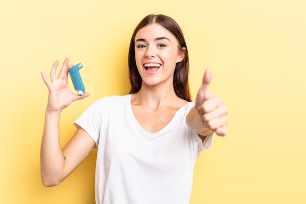 Jeune femme hispanique se sentant fière, souriante positivement avec les pouces vers le haut. concept d'asthme