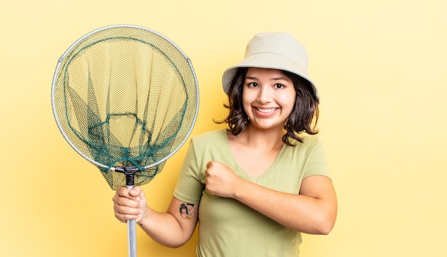 Jeune femme hispanique se sentant heureuse et confrontée à un défi ou à la célébration. concept de filet de pêcheur