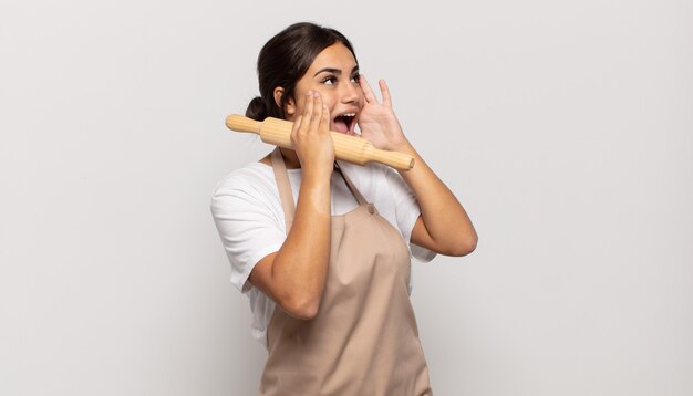 Jeune femme hispanique se sentant heureuse, excitée et surprise, regardant de côté avec les deux mains sur le visage