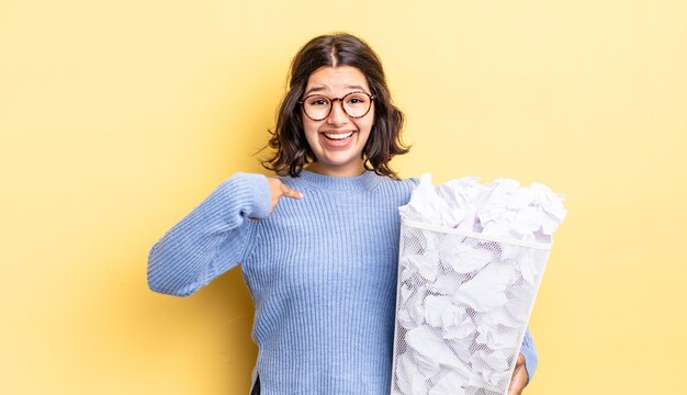 jeune femme hispanique se sentant heureuse et se montrant elle-même avec un concept excité de poubelle d'échec