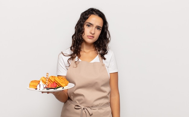 Jeune femme hispanique se sentant perplexe et confus, avec une expression stupide et stupéfaite en regardant quelque chose d'inattendu