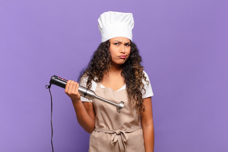 Photo jeune femme hispanique se sentant perplexe et confuse, avec une expression stupide et abasourdie en regardant quelque chose d'inattendu. concept de chef