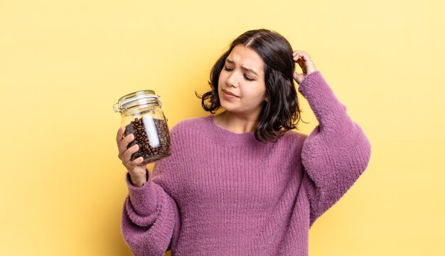 Jeune femme hispanique se sentant perplexe et confuse, se grattant la tête. concept de grains de café