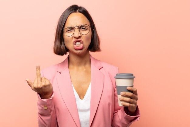 Jeune femme hispanique se sentant provocante, agressive et obscène, retournant le majeur, avec une attitude rebelle