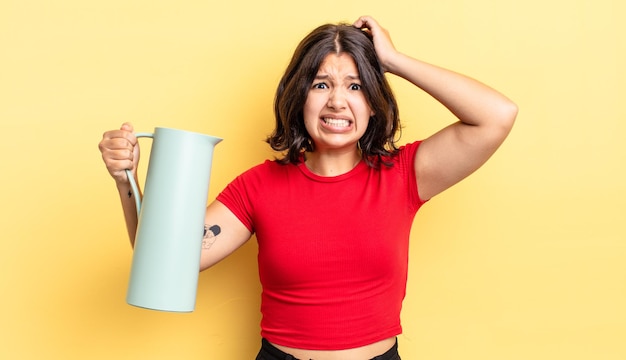 Jeune femme hispanique se sentant stressée anxieuse ou effrayée avec les mains sur le concept de thermos tête