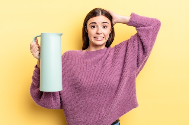 Jeune femme hispanique se sentant stressée, anxieuse ou effrayée, les mains sur la tête. concept de thermos à café