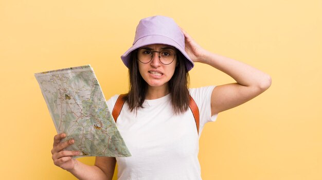 Jeune femme hispanique se sentant stressée anxieuse ou effrayée avec les mains sur la tête touriste et concept de carte