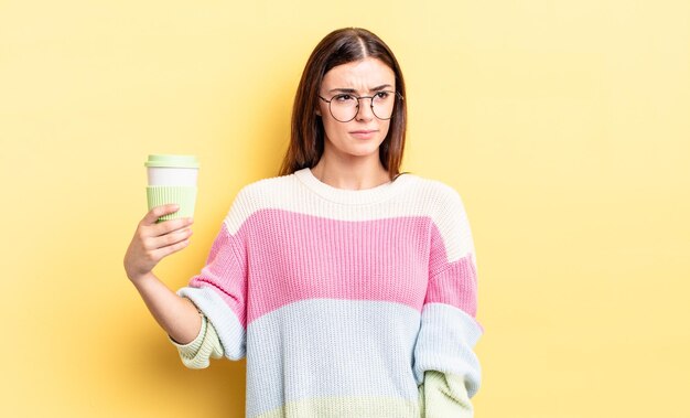 Jeune femme hispanique se sentant triste, bouleversée ou en colère et regardant sur le côté. concept de café à emporter