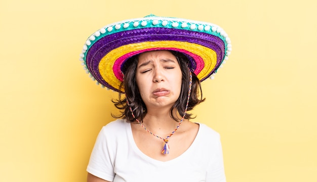 jeune femme hispanique se sentant triste et pleurnicharde avec un regard malheureux et pleurant. concept de chapeau mexicain