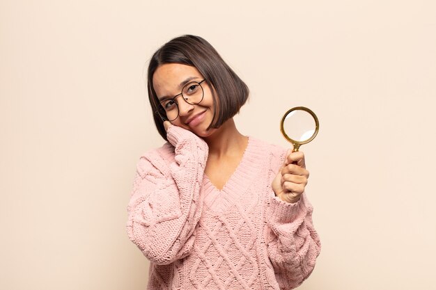 Jeune femme hispanique se sentir amoureux et à la recherche de mignon, adorable et heureux, souriant romantiquement avec les mains à côté du visage