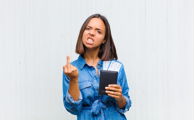 Jeune femme hispanique se sentir en colère, ennuyé, rebelle et agressif, renversant le majeur, ripostant