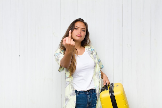 Jeune femme hispanique se sentir en colère, ennuyé, rebelle et agressif, retournant le majeur, ripostant