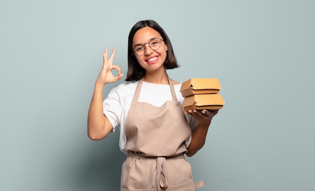 Jeune femme hispanique se sentir heureuse, détendue et satisfaite, montrant son approbation avec un geste correct, souriant