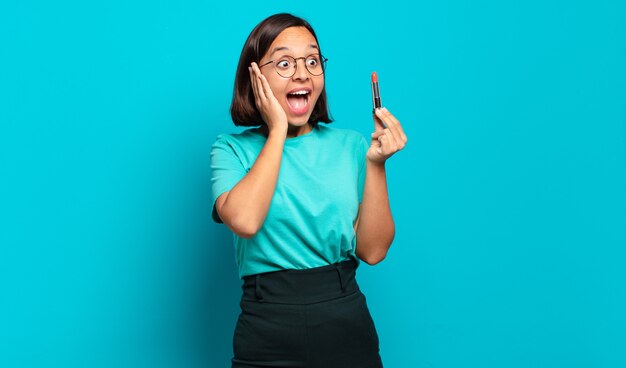 Jeune femme hispanique se sentir heureuse, excitée et surprise, regardant sur le côté avec les deux mains sur le visage