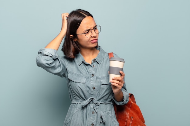 Jeune femme hispanique se sentir perplexe et confus, se gratter la tête et regarder sur le côté