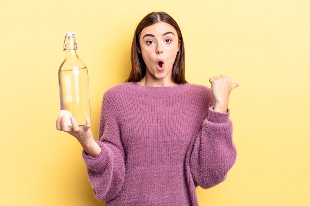 jeune femme hispanique semblant étonnée d'incrédulité. concept de bouteille d'eau