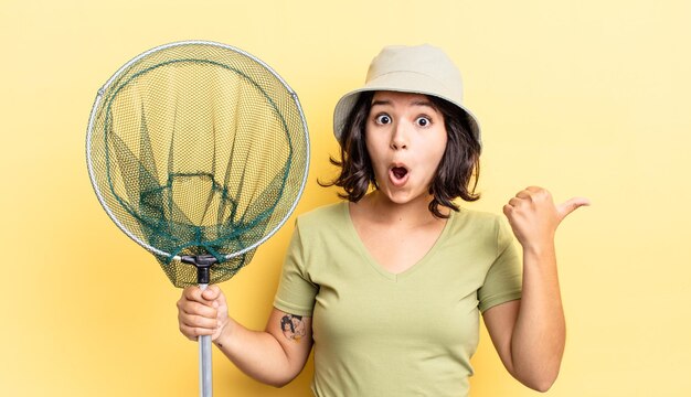 Photo jeune femme hispanique semblant étonnée d'incrédulité. concept de filet de pêcheur