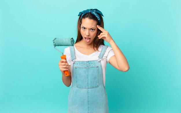 Photo jeune femme hispanique semblant surprise, réalisant une nouvelle pensée, idée ou concept et peignant un mur