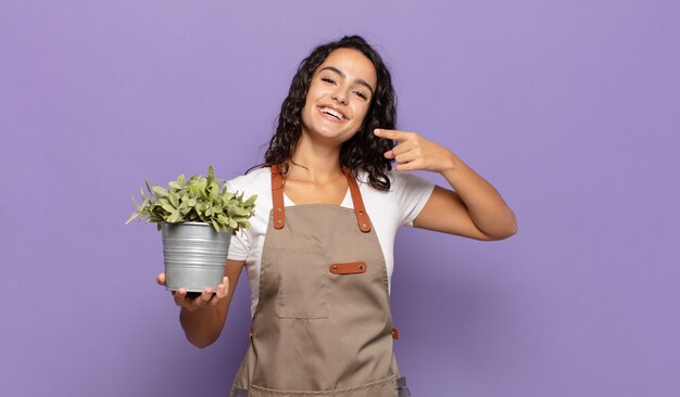 Jeune femme hispanique souriant avec confiance en montrant son large sourire, attitude positive, détendue et satisfaite