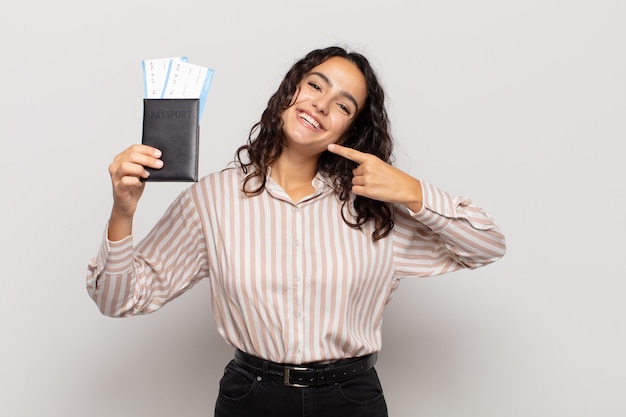 Jeune femme hispanique souriant avec confiance en montrant son large sourire, attitude positive, détendue et satisfaite