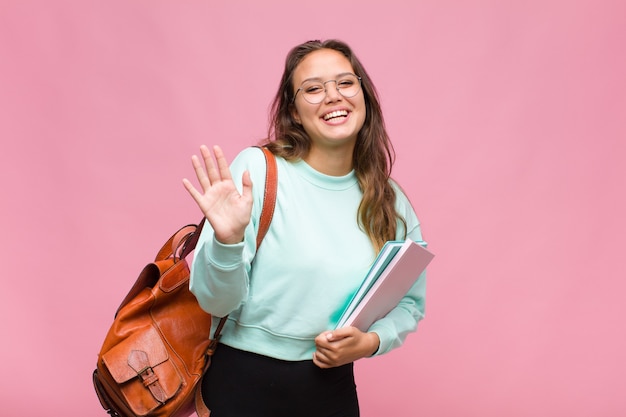 Jeune femme hispanique souriant et à la sympathique, montrant le numéro un ou d'abord avec la main en avant, compte à rebours