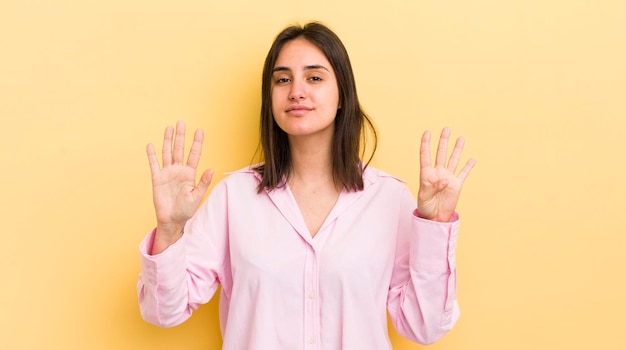 Jeune femme hispanique souriante et amicale montrant le numéro neuf ou neuvième avec la main en avant compte à rebours