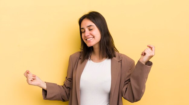 Jeune femme hispanique souriante se sentant insouciante détendue et heureuse dansant et écoutant de la musique s'amusant lors d'une fête