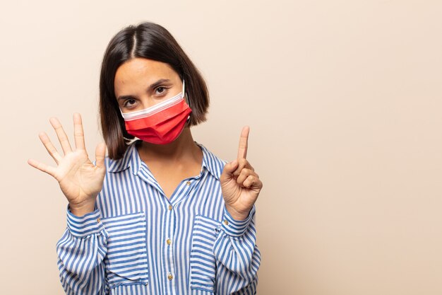 Jeune femme hispanique souriante et à la sympathique, montrant le numéro six ou sixième avec la main en avant