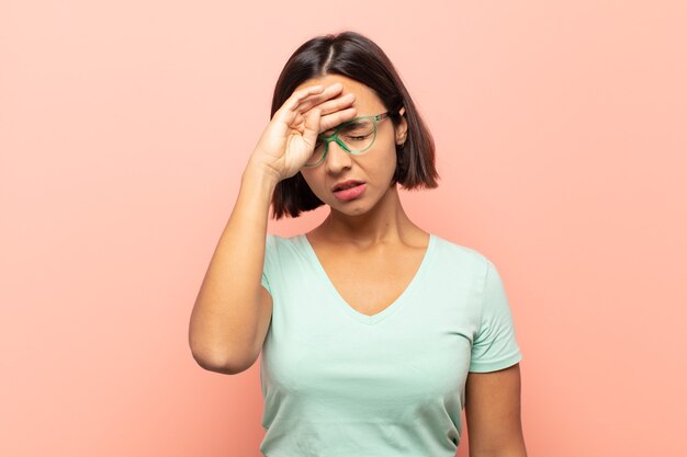 Jeune femme hispanique à stressé, fatigué et frustré, séchant la sueur du front, se sentant désespérée et épuisée