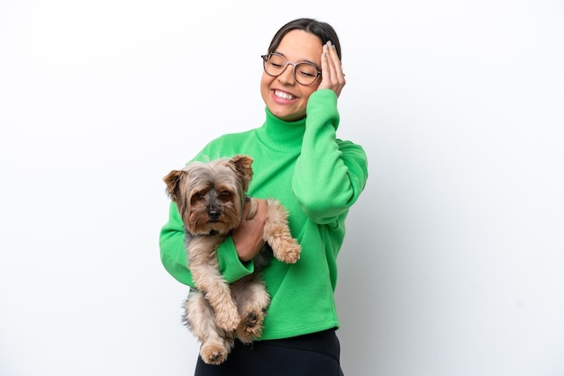 Jeune femme hispanique tenant un chien isolé sur fond blanc a réalisé quelque chose et a l'intention de trouver la solution