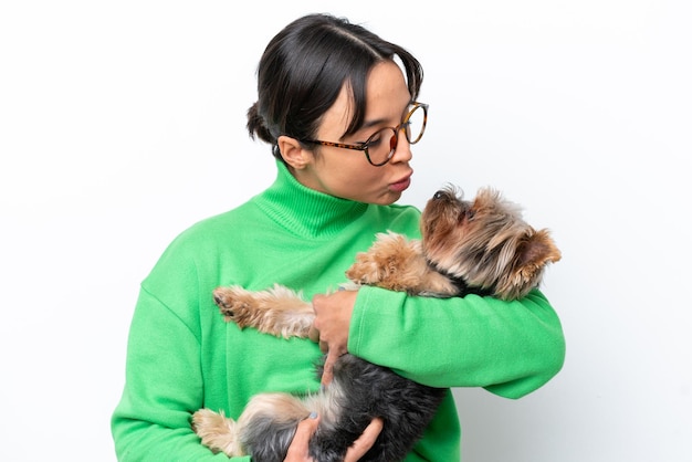 Jeune femme hispanique tenant un chien isolé sur fond blanc