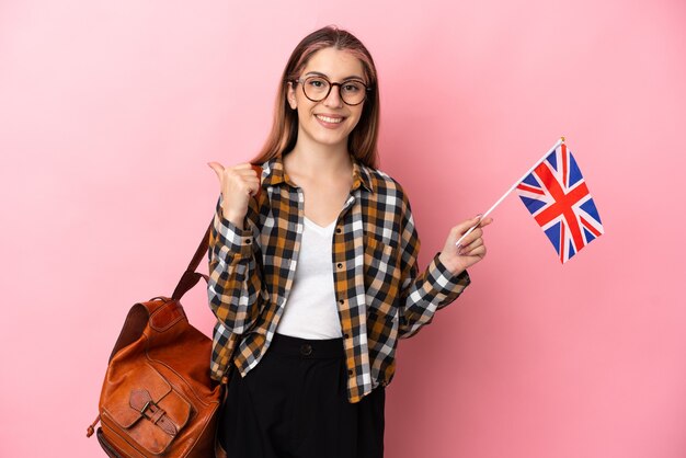 Jeune femme hispanique tenant un drapeau du Royaume-Uni isolé