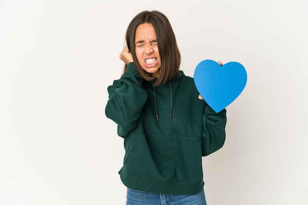 Jeune Femme Hispanique Tenant Une Forme De Coeur Couvrant Les Oreilles Avec Les Mains.