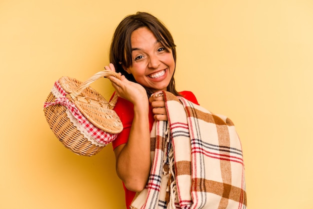 Jeune femme hispanique va le faire pique-nique isolé sur fond jaune