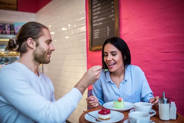 Jeune femme et homme dégustation de dessert dans un restaurant