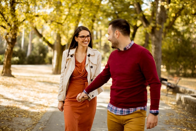 Jeune femme et homme marchant dans le parc de la ville, main dans la main