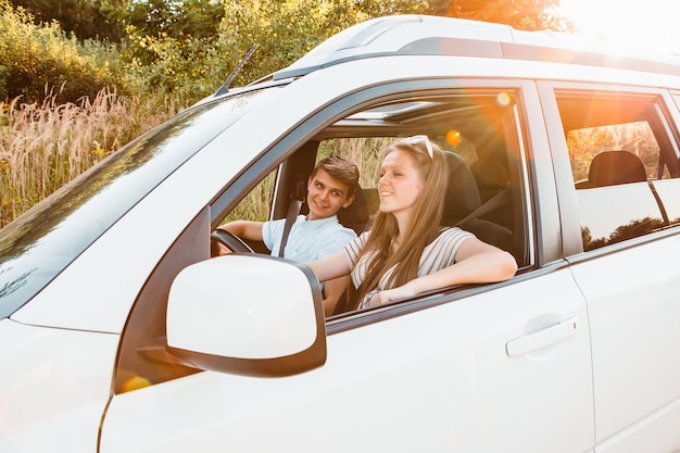 Jeune femme avec homme en voiture. voyage en voiture d'été