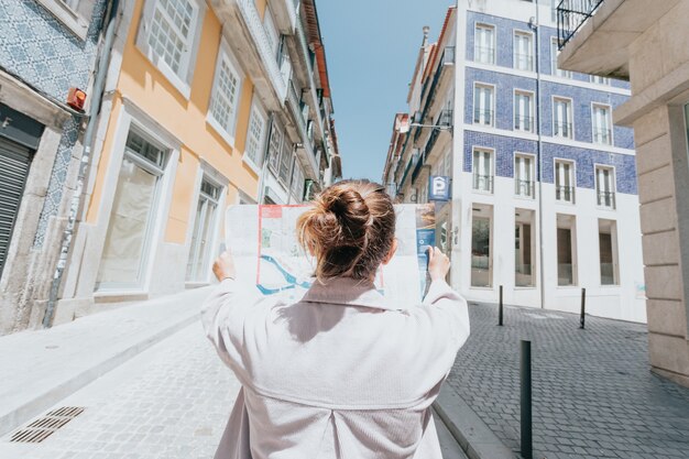 Jeune femme indépendante utilisant une carte au milieu d'une rue en europe, journée ensoleillée, journée d'été, concepts de voyage, nouveaux horizons