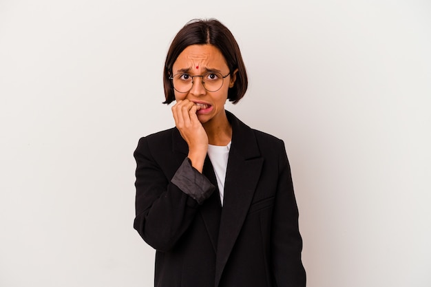 Photo jeune femme indienne d'affaires isolée sur fond blanc, se ronger les ongles, nerveuse et très anxieuse.