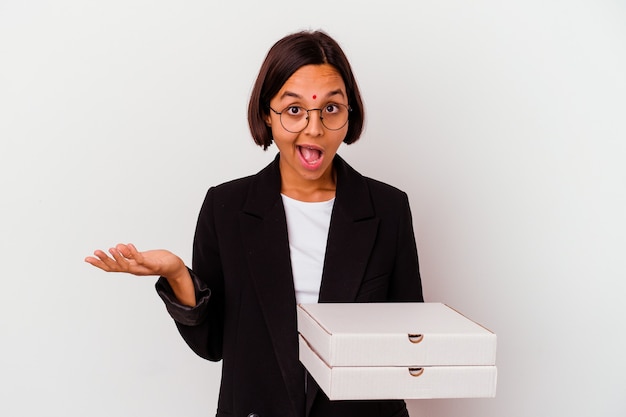 Jeune femme indienne d'affaires tenant des pizzas isolées surpris et choqués.