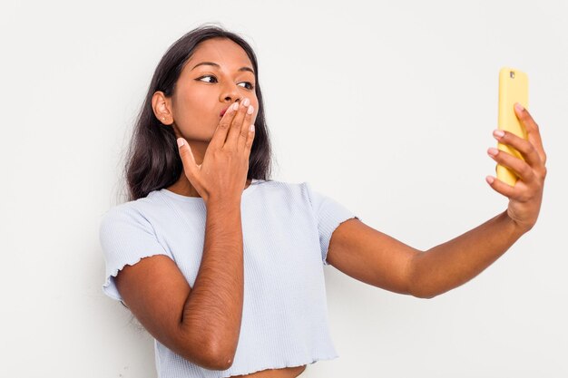 Jeune femme indienne à l'aide de téléphone portable isolé sur fond blanc