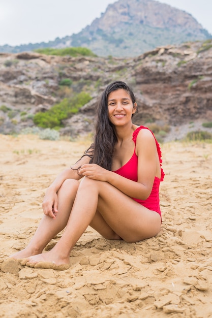 Jeune femme indienne assise sur la plage