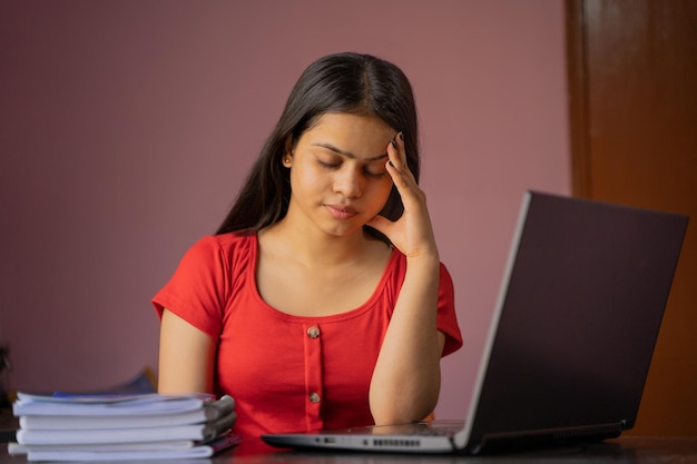 Jeune femme indienne épuisée massant la tête souffrant de maux de tête