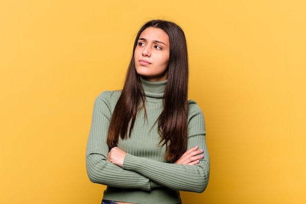 Jeune femme indienne isolée sur fond jaune rêvant d'atteindre les objectifs et les buts