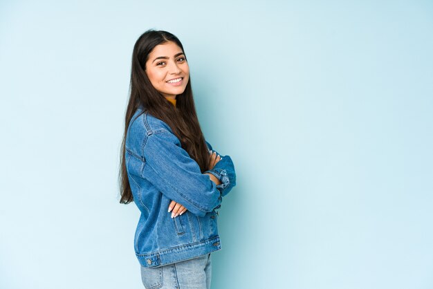 Jeune femme indienne isolée sur mur bleu heureux, souriant et joyeux.